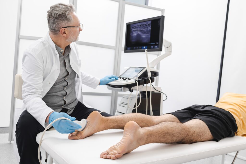 Doctor performing an ultrasound examination on a patient's foot.
