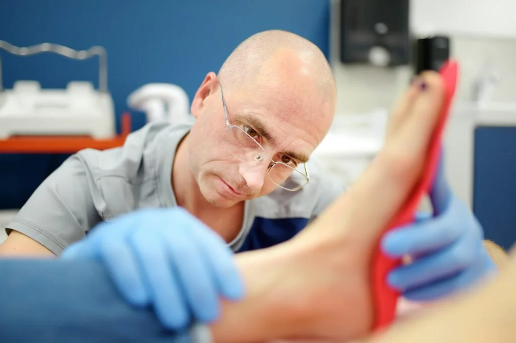 Healthcare professional fitting a foot orthotic on a patient